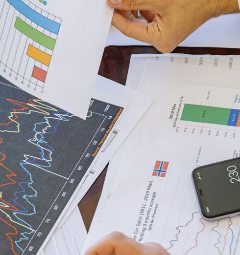 Insurance - Business professionals analyzing financial charts and graphs during a meeting.