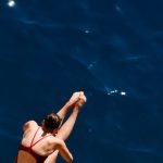 Reputational Risk - Female Diver Mid-Air Over Deep Blue Sea