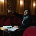 Scenario Planning - A theater director gestures in an empty auditorium during a rehearsal planning session.