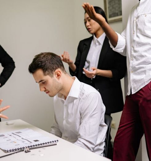 Proactive Management - Business professionals engaged in a tense discussion at the office, highlighting workplace conflict.