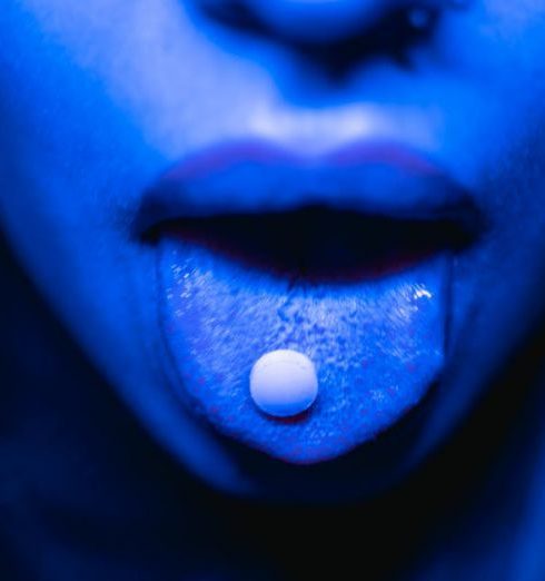 Risk Impact - Dramatic close-up of a person with a tablet on their tongue in blue lighting.