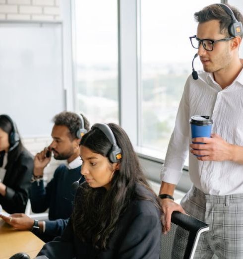 Employee Training - A diverse group of employees working together in a bright, modern call center with headsets.