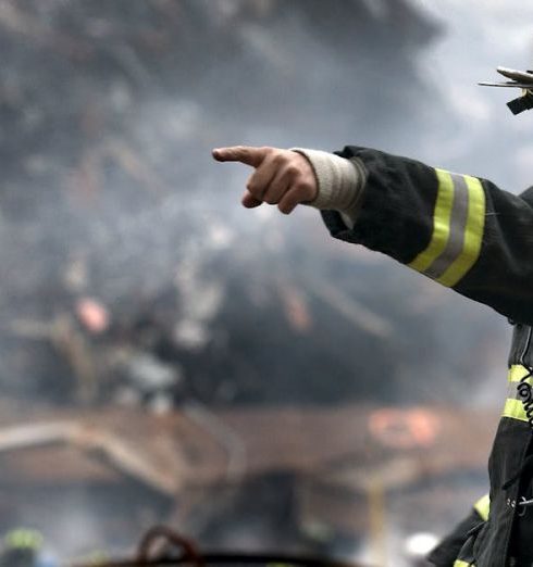 Natural Disaster - A firefighter in action at a disaster scene, directing rescue operations amidst smoke and debris.