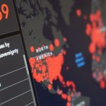 International Risks - Blurred world map with total number of people infected by coronavirus and statistics of various countries