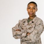 Core Values - Portrait of a female African American soldier in a US Marines uniform on a white background.