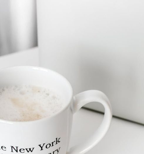 Work Environment - A clean, minimalist workspace featuring a laptop, coffee mug, and mouse for inspiration.