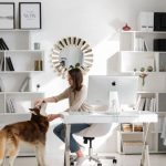 Remote Work - Bright home office featuring a woman petting her dog at the desk. Ideal for remote work themes.