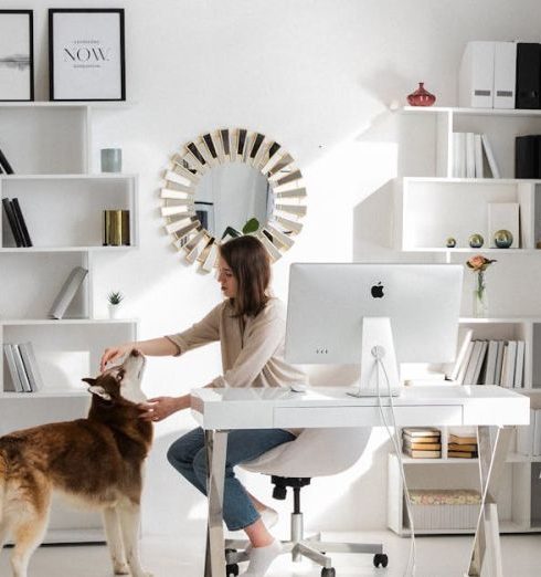 Remote Work - Bright home office featuring a woman petting her dog at the desk. Ideal for remote work themes.