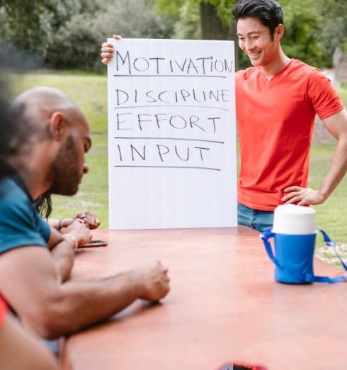 Leadership Development - A diverse group of adults engaged in a motivational team building session outdoors.