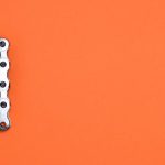 Objectives - Metal chain forming the number one on an orange background, ideal for design concepts.