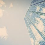 Growth - A stunning skyscraper in London, Ontario reflecting clouds on its glass facade.