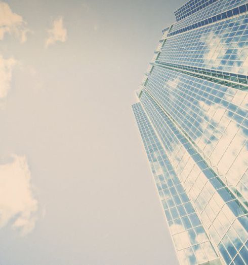 Growth - A stunning skyscraper in London, Ontario reflecting clouds on its glass facade.