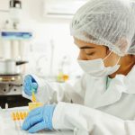 Data Collection - A scientist wearing protective gear performs a meticulous experiment in a laboratory setting.