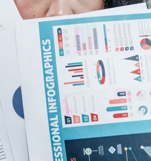 Descriptive Analytics - Professional woman holding infographics and financial documents demonstrating data analysis.