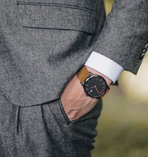 Trends - Close-up of a man in a tailored suit wearing an elegant wristwatch outdoors, exuding fashion and sophistication.