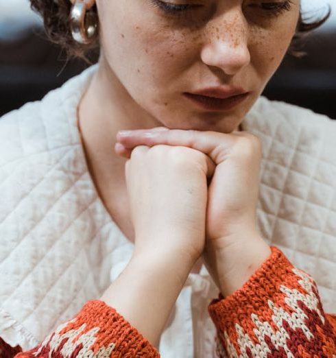 Competitive Analysis - A woman in a knitted sweater contemplating her next move in a chess game indoors.