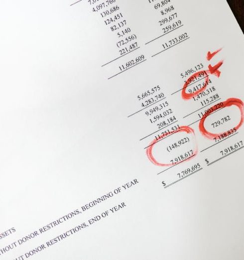 Data Accuracy - Financial statement with red annotations on a wooden table.