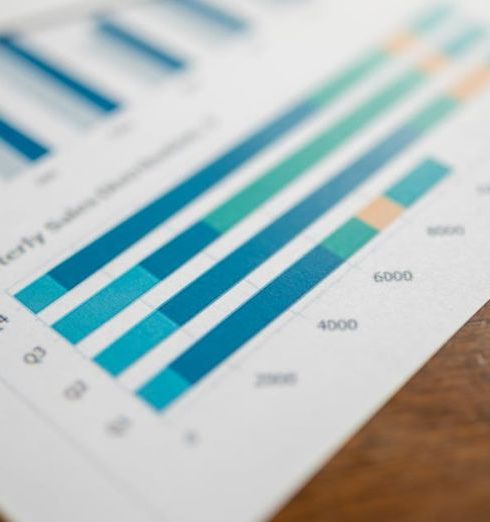 Metric Tracking - Close-up of a quarterly sales report showing bar charts on paper.