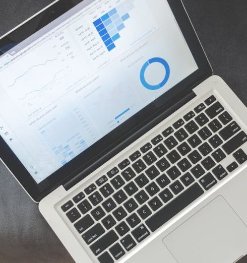 Cloud-Based Analytics - Overhead view of a laptop showing data visualizations and charts on its screen.