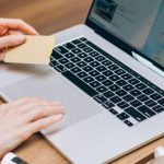 Data Privacy - A person using a laptop and credit card, surrounded by a magazine and coffee cup.