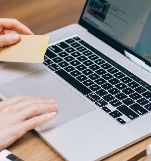 Data Privacy - A person using a laptop and credit card, surrounded by a magazine and coffee cup.