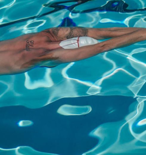 Performance Improvement - A male swimmer in a swimming pool, captured underwater, practicing his technique.