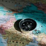 Countries - Close-up image of compass on a world map highlighting travel direction and exploration.