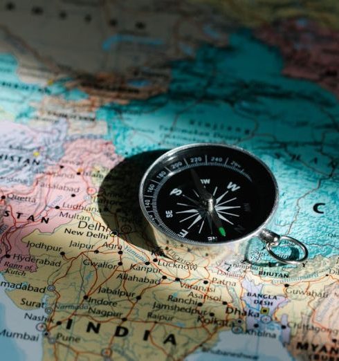 Countries - Close-up image of compass on a world map highlighting travel direction and exploration.