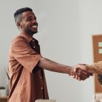 Partners - Business team members shaking hands during a meeting, demonstrating cooperation and teamwork.