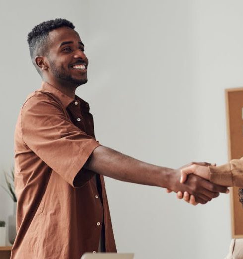 Partners - Business team members shaking hands during a meeting, demonstrating cooperation and teamwork.