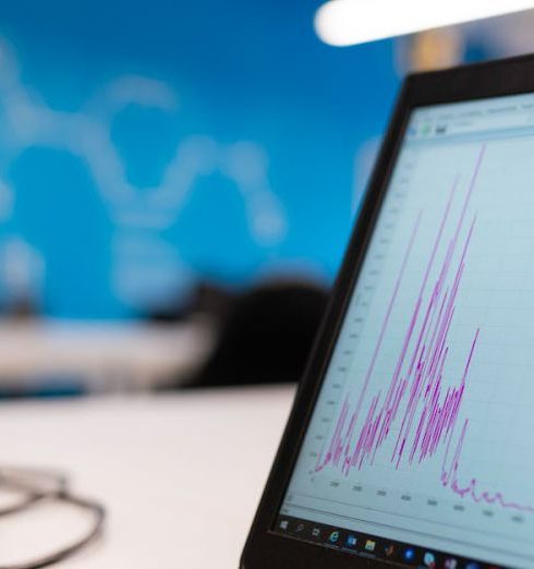 Data Analytics - Laptop displaying data analytics graph in a modern office setting, symbolizing growth and technology.