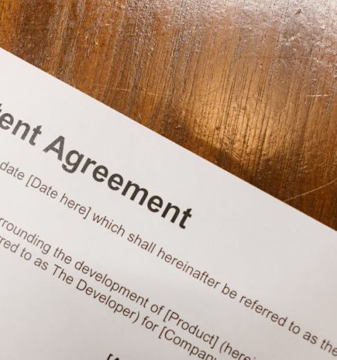 Intellectual Property - Detailed close-up of a patent agreement document on a polished wooden table.