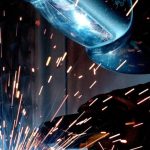 Manufacturing - A focused welder works with metal in an industrial setting, creating vibrant sparks.