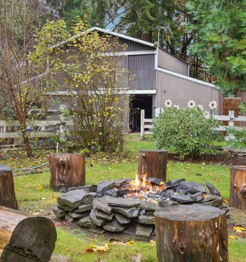 Backyard Seating - Cozy outdoor fire pit with log stools in a tranquil backyard setting.