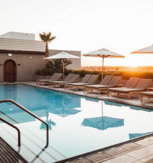 Poolside Furniture - Lounge Chairs With Umbrella Near Swimming Pool