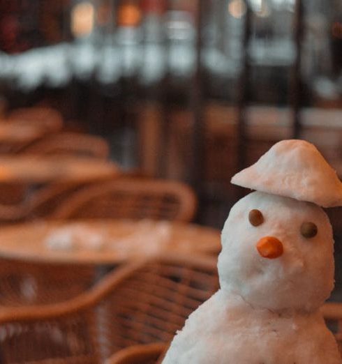 Outdoor Seating - Charming snowman on table in a Baku café with warm, festive lighting.