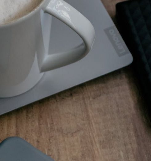 Modern Setup - Cozy workspace with laptop, phone, coffee, and external hard drive on wooden table.