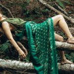 Outdoor Recliners - A woman laying on a tree branch in green dress