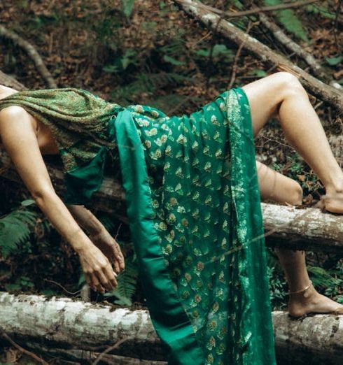 Outdoor Recliners - A woman laying on a tree branch in green dress