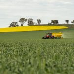 Fertilizing - Tractor with Spreader on Canola Field