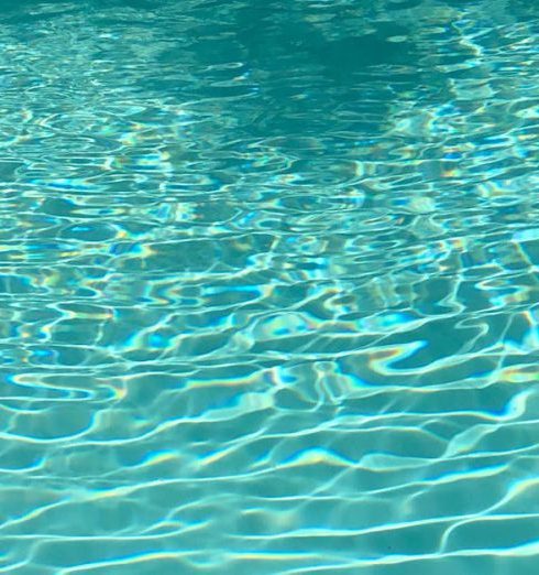 Bottom Watering - From above of clear blue water of rippling pool on sunny day as abstract background