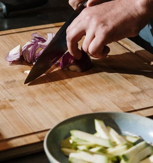 Chef’s Knife - Person Slicing Vegetable on Chopping Board