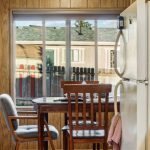 Kitchen Layout - Warm retro kitchen interior featuring a dining area and large window with natural light.