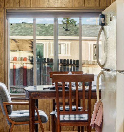 Kitchen Layout - Warm retro kitchen interior featuring a dining area and large window with natural light.