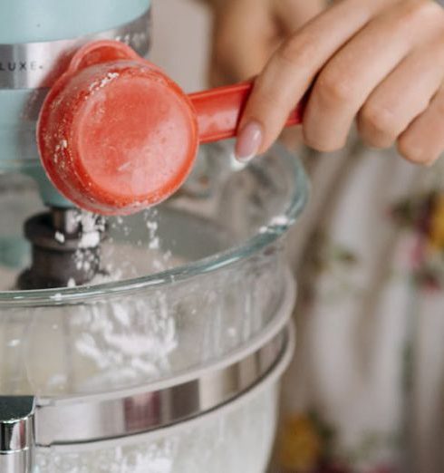 Stand Mixer - A Person Putting Flour in a Batter Mixture