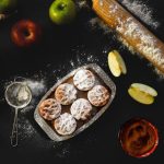 Bakeware - Flat lay of apple pie preparation with fresh apples, rolling pin, and pastry on dark surface.