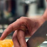 Kitchen Tools - Selective Focus Photo of Person Slicing Vegetable on Chopping Board