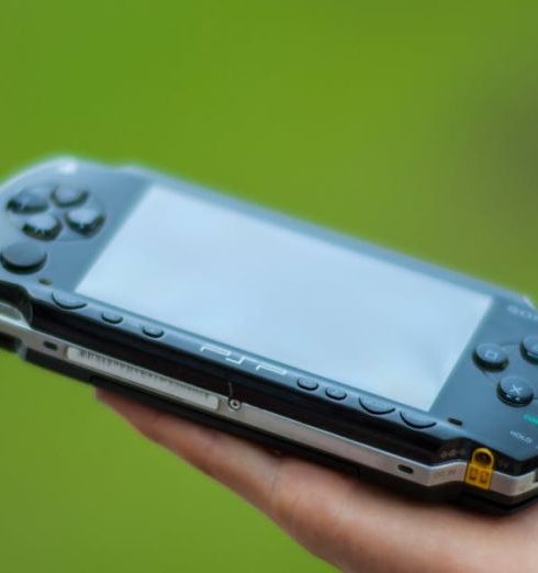 Outdoor Gadgets - Closeup Photography of Person Holding Black Sony Psp Handheld Console