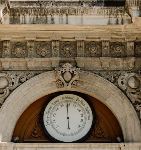 Entryway - Elegant historical building facade with ornate details and a clock above wooden doors.