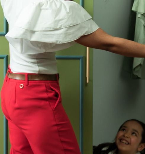 Kids’ Closets - A Woman in Red Pants and White Shirt Looking at Her Daughter Inside the Closet